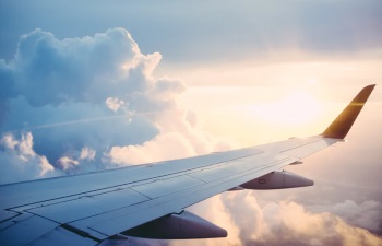Wing of aircraft flying over the clouds